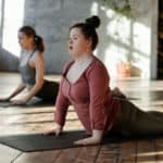 Two women doing Yoga in a studio. One has Down Syndrome.
